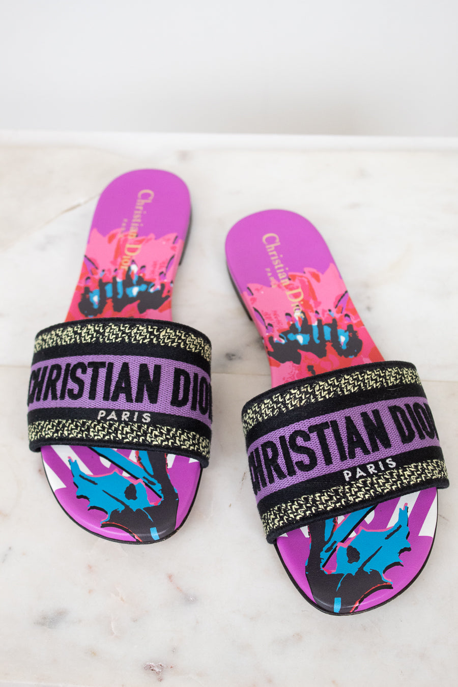 Pair of Christian Dior slides with colorful design on a white background