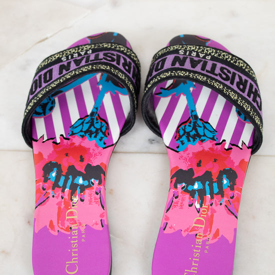 Pair of colorful sandals with 'Christian Dior' branding on a marble background