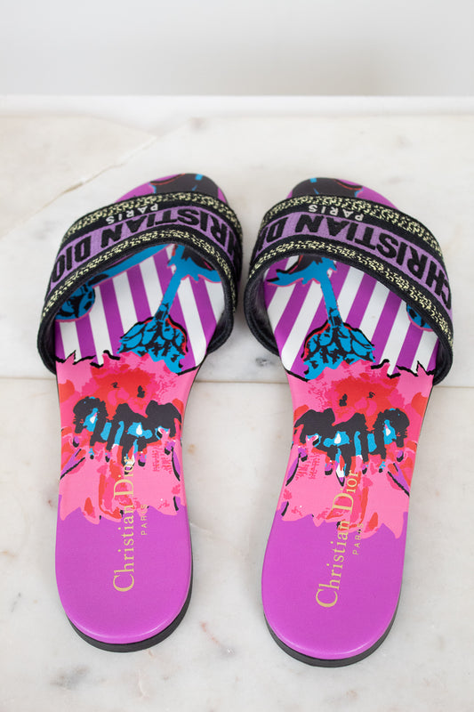 Pair of colorful sandals with 'Christian Dior' branding on a marble background