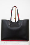 Black leather tote bag with red accents and gold spike accents on handle on a white background