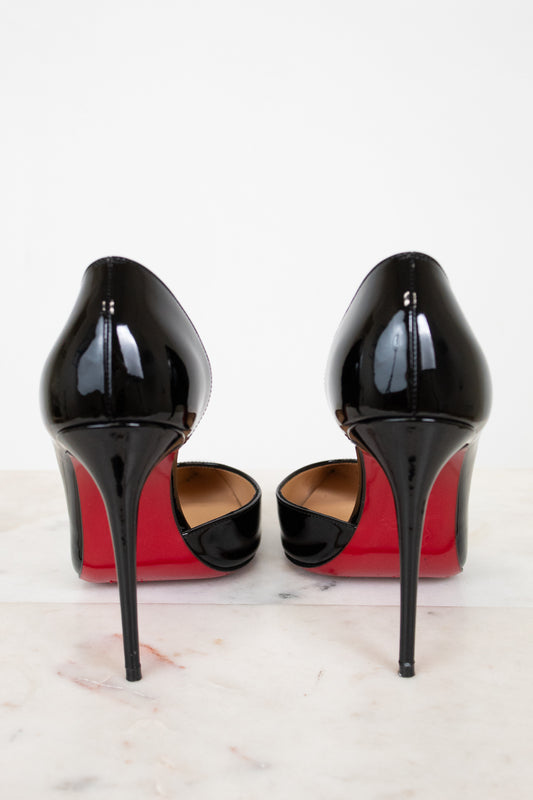 Black high-heeled shoes with red soles on a white background