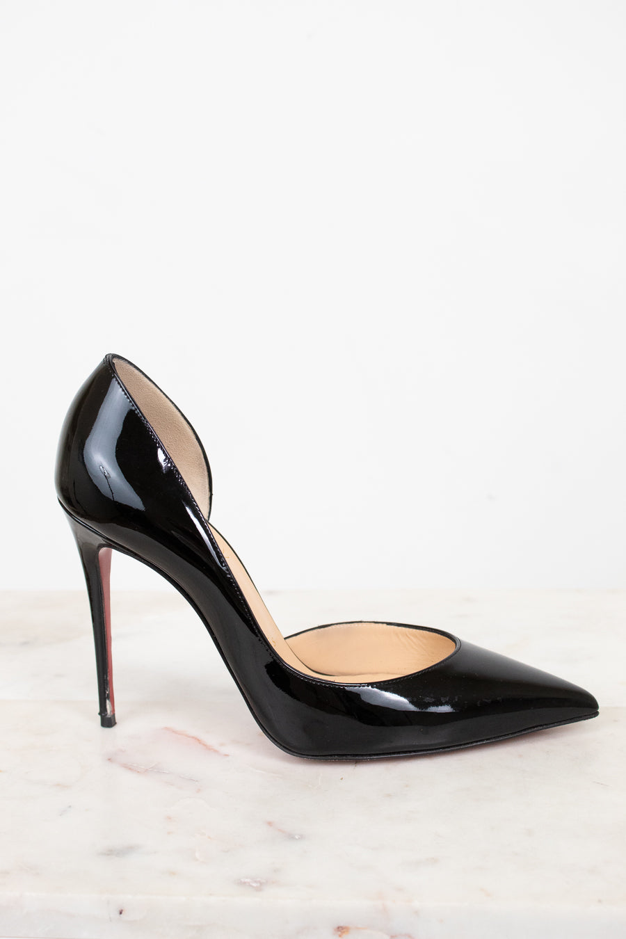 Black patent high-heeled shoe on a light background