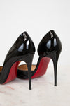 Black high-heeled shoes with red soles on a light background