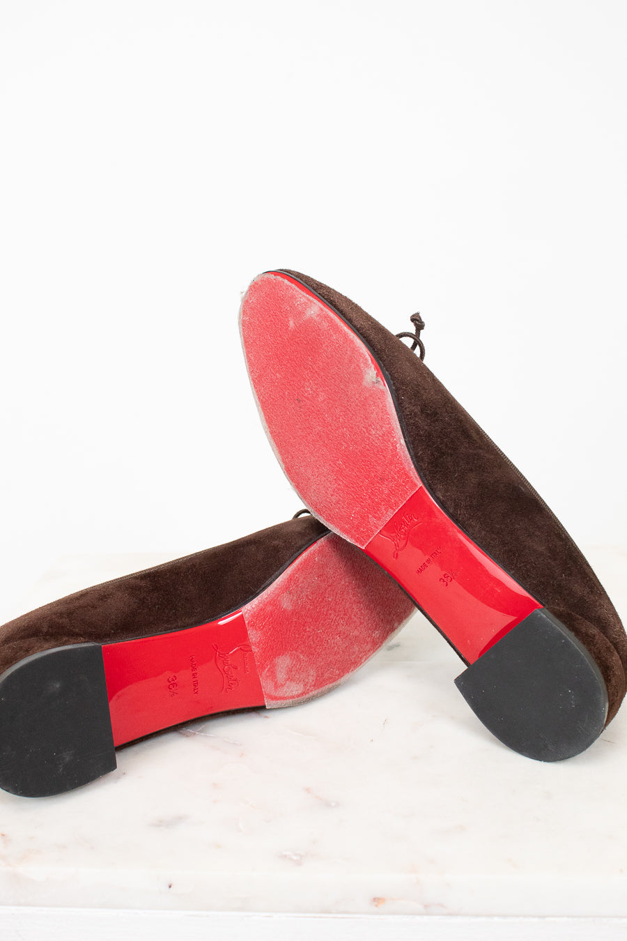 Red bottoms of brown suede flats