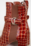 Brown crocodile-patterned handbag with a gold buckle on a white background