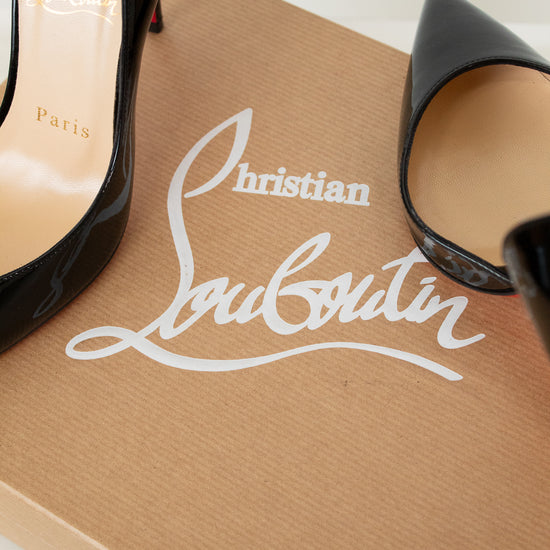Black high-heeled shoes on a brown Christian Louboutin box with white logo.