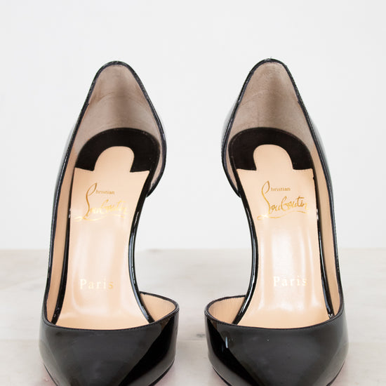 Black high-heeled shoes with a brand logo on a light background
