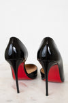 Black high-heeled shoes with red soles on a light background