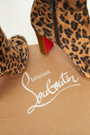 Leopard print boots with a red sole on a beige surface featuring Christian Louboutin branding.