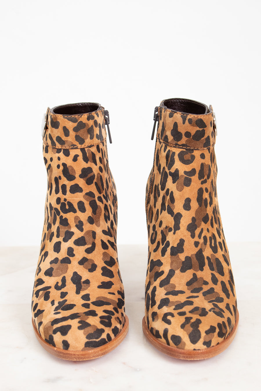 Pair of leopard print ankle boots on a white background