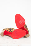 Close-up of red soles with leopard print pattern on a white background