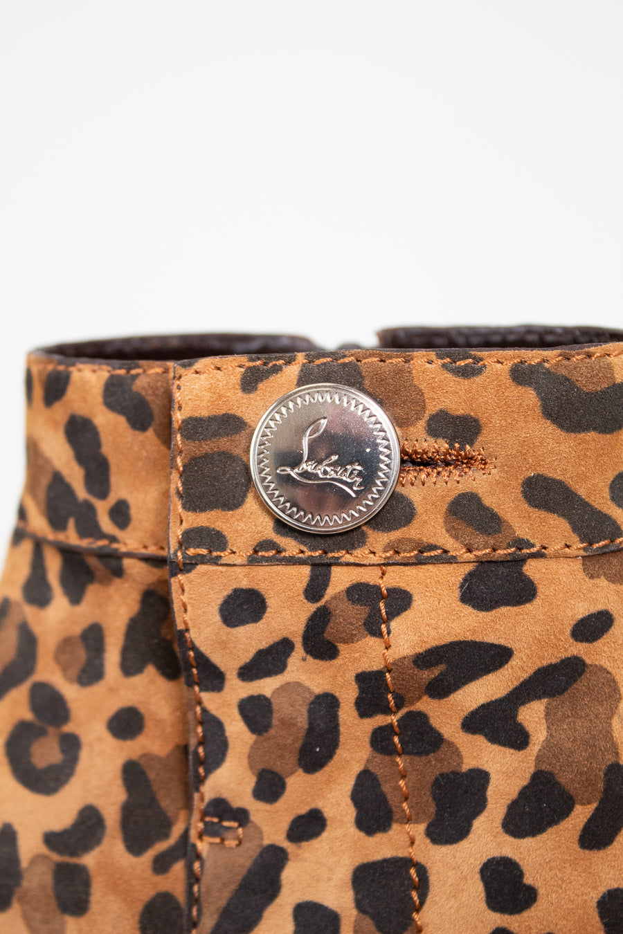 Leopard print boot close up with a button on a white background
