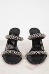 Black sandals with silver embellishments and 'Paris' text on a white background
