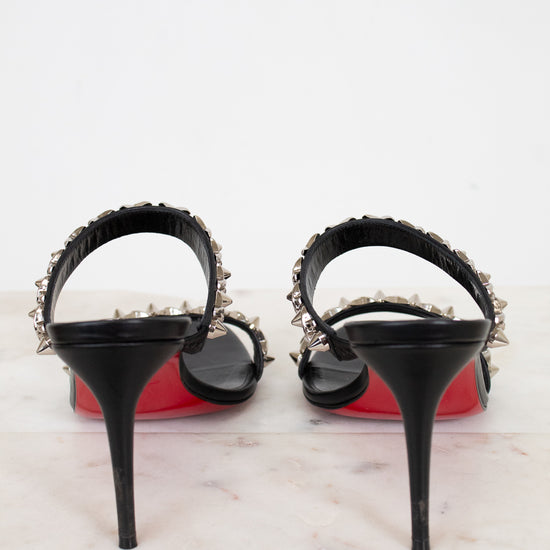 Black high-heeled shoes with studded details on a light background