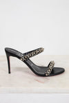 Black high-heeled sandal with embellishments on a light background