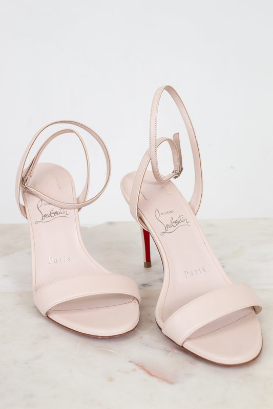 Pair of pink high-heeled sandals with open toes on a light background
