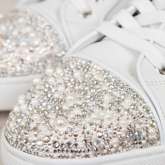 White sneakers with crystal and pearl embellishments on a light background