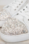 White sneakers with crystal and pearl embellishments on a light background