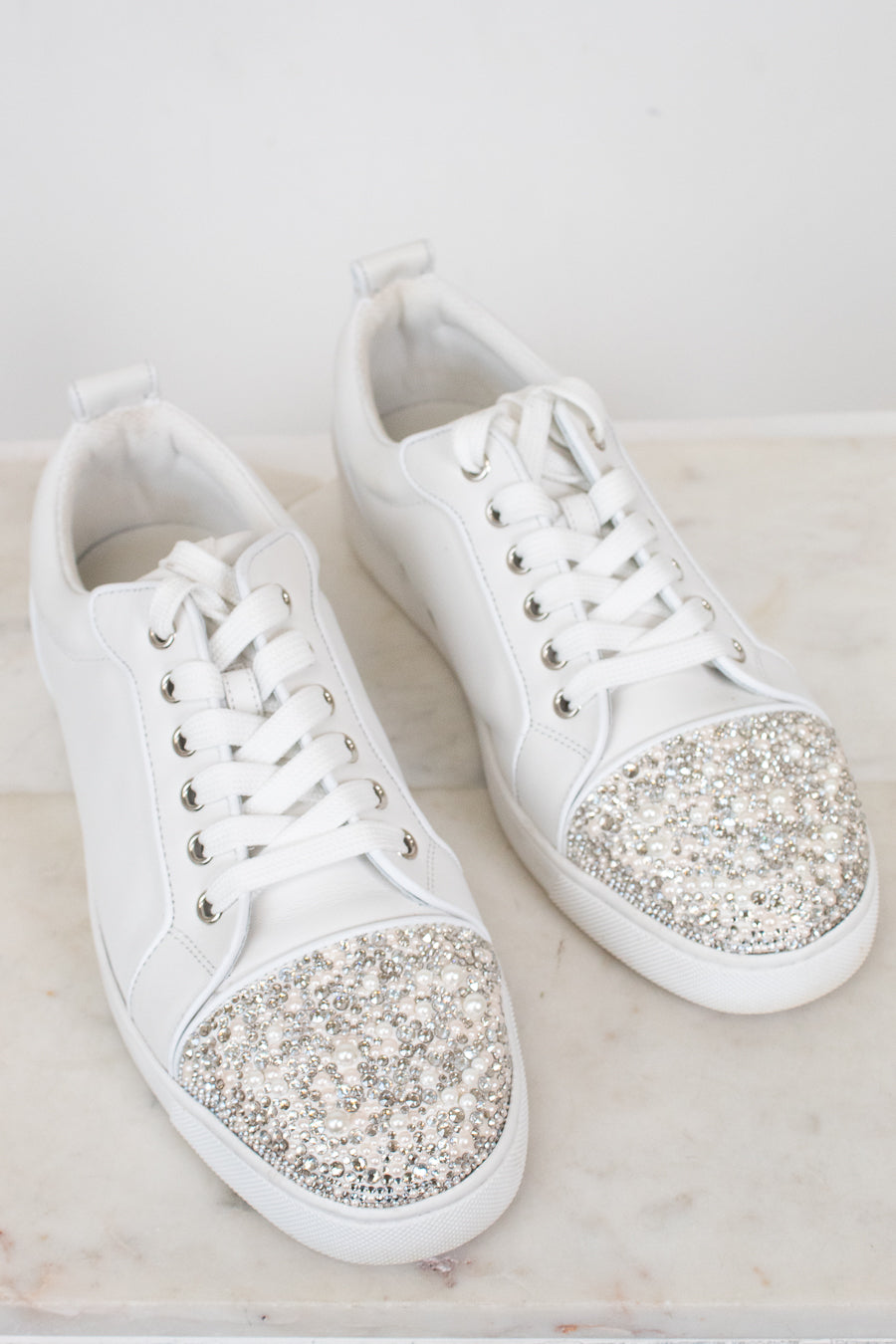 White sneakers with glittery accents on a light background