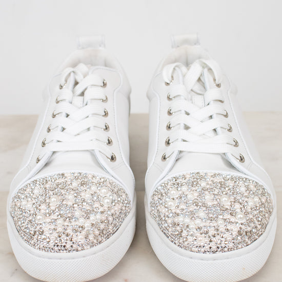 White sneakers with crystal and pearl accents on a light background