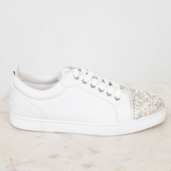 White sneaker with rhinestone embellishments on a light gray background