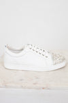 White sneaker with rhinestone embellishments on a light gray background