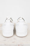 Pair of white sneakers on a light gray background