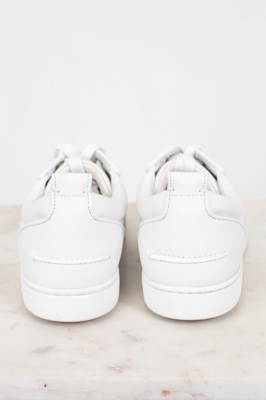 Pair of white sneakers on a light gray background