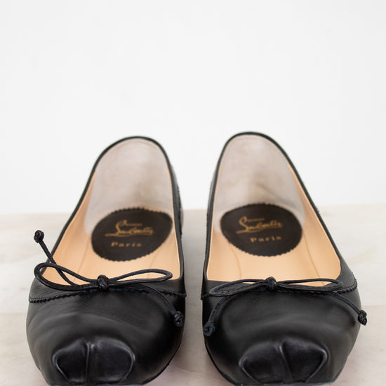 Pair of black high-heeled shoes with brand logo on a light background