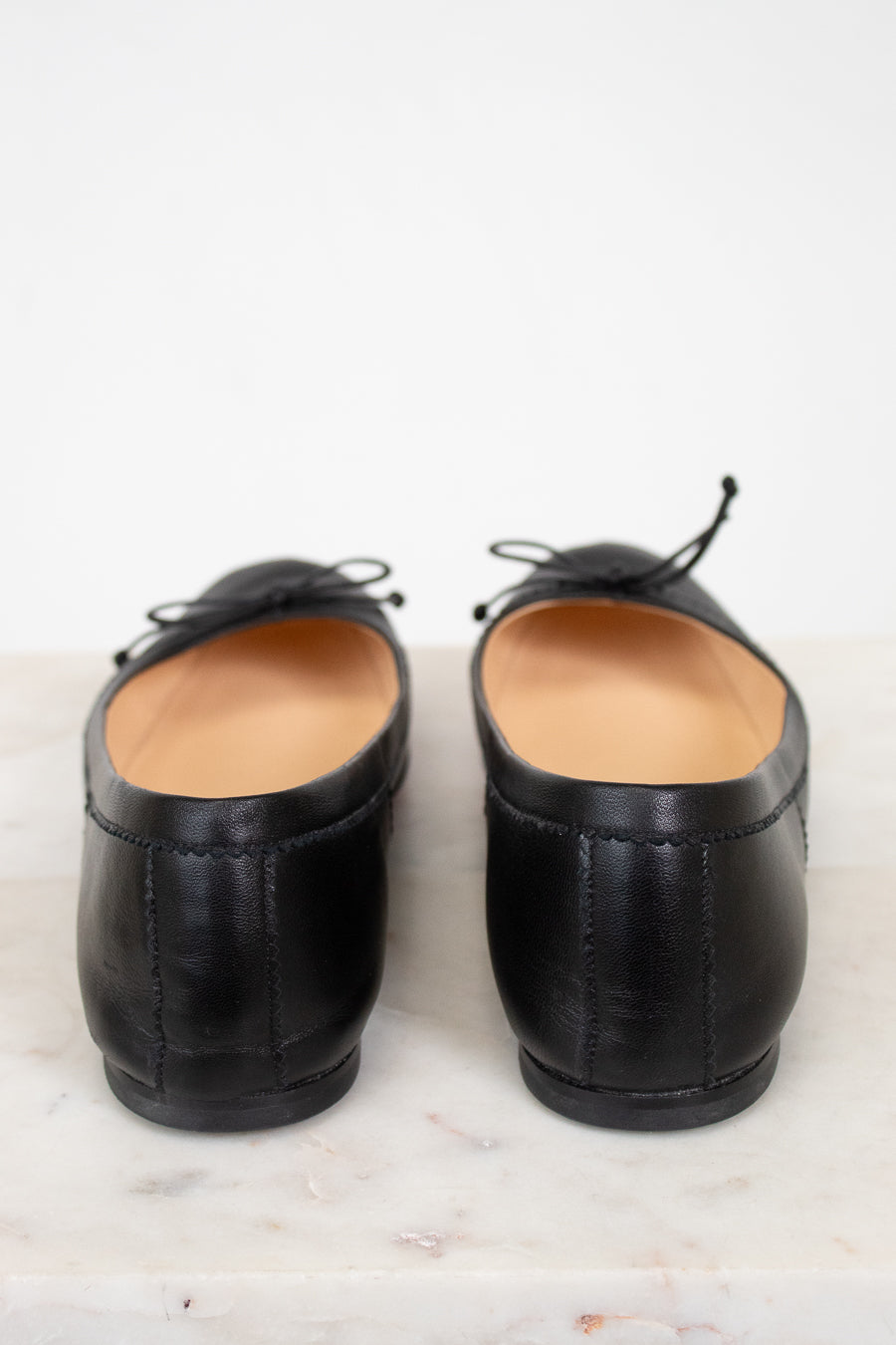Pair of black leather shoes on a light marble surface