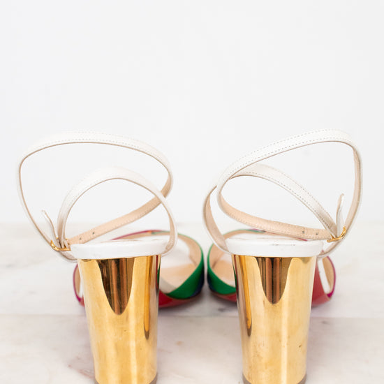Gold chunky heel of shoes with white soles on a light background
