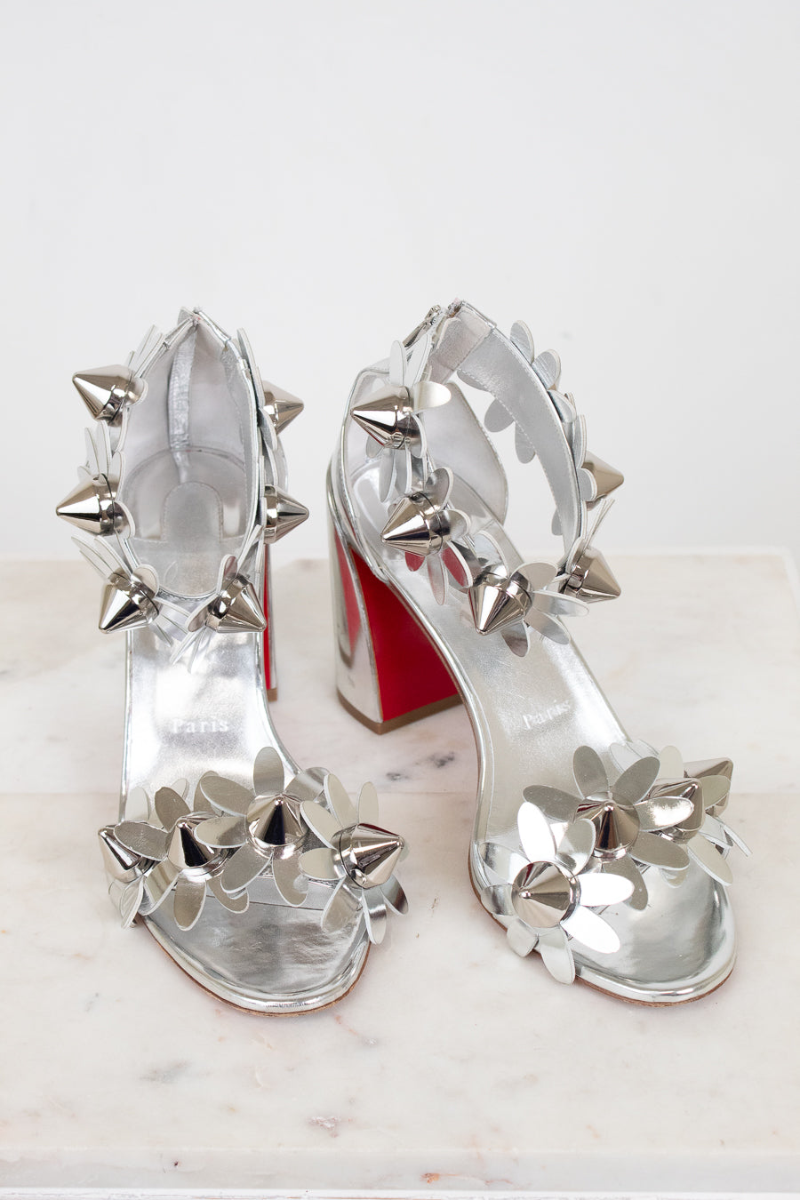 Silver studded high-heeled shoes on a white background