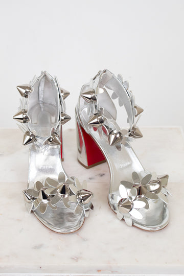 Silver studded high-heeled shoes on a white background