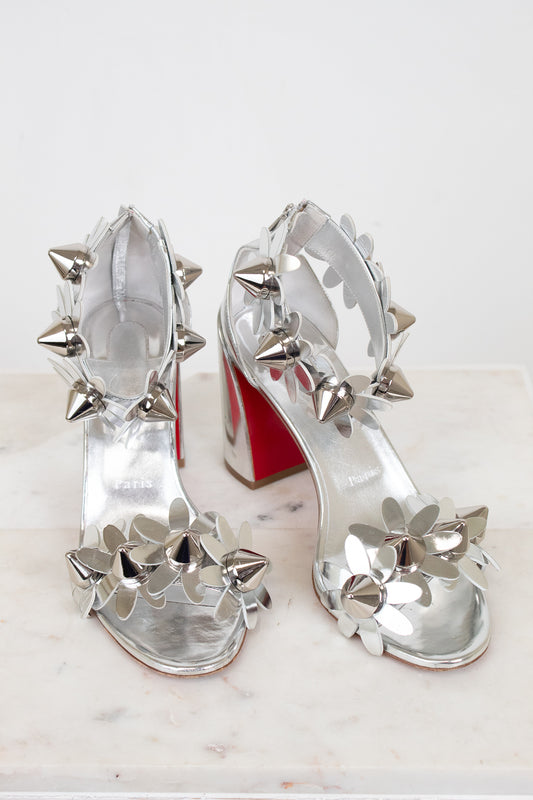 Silver studded high-heeled shoes on a white background