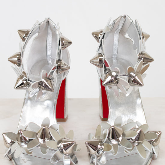 Silver studded high-heeled shoes on a white background