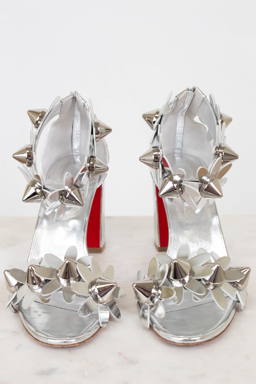 Silver studded high-heeled shoes on a white background