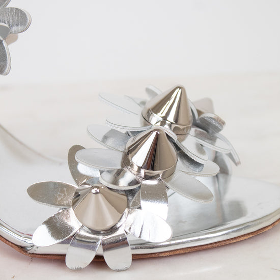 Close-up of silver studded floral shoe on a white background