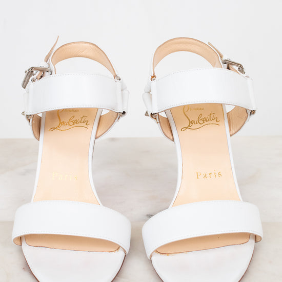 White high-heeled sandals on a light background