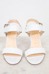 White high-heeled sandals on a light background