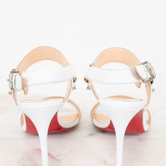 White high-heeled shoes with red bottom soles on a white background