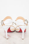 White high-heeled shoes with red bottom soles on a light background