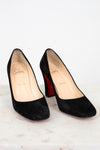 Black high-heeled shoes with red soles on a white background