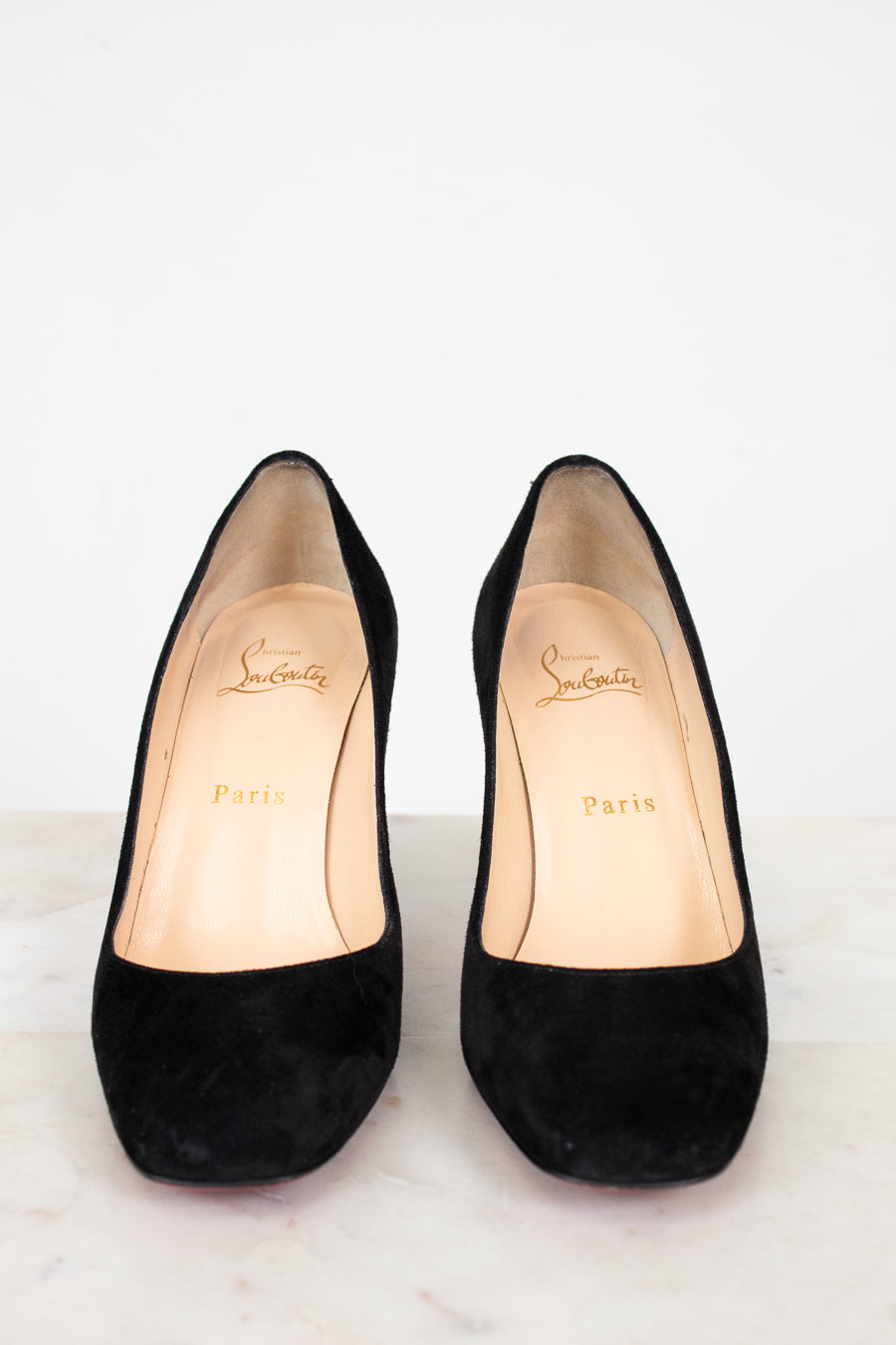 Pair of black high-heeled shoes with brand logo on a white background