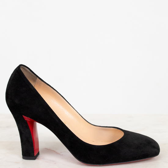 Black high-heeled shoe with a red sole on a white background