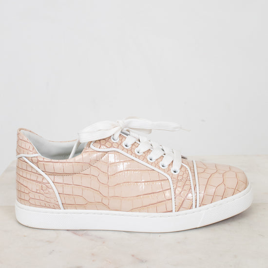 Beige sneaker with white sole on a light marble surface