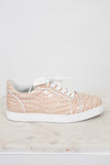 Beige sneaker with white sole on a light marble surface