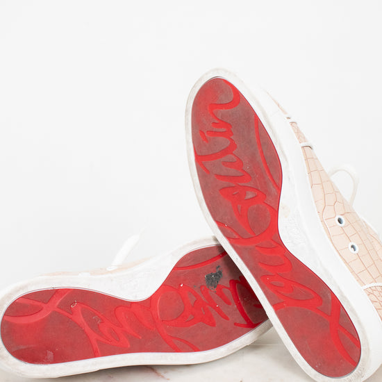 Red soles of sneakers on a light gray surface