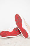 Red soles of sneakers on a light gray surface