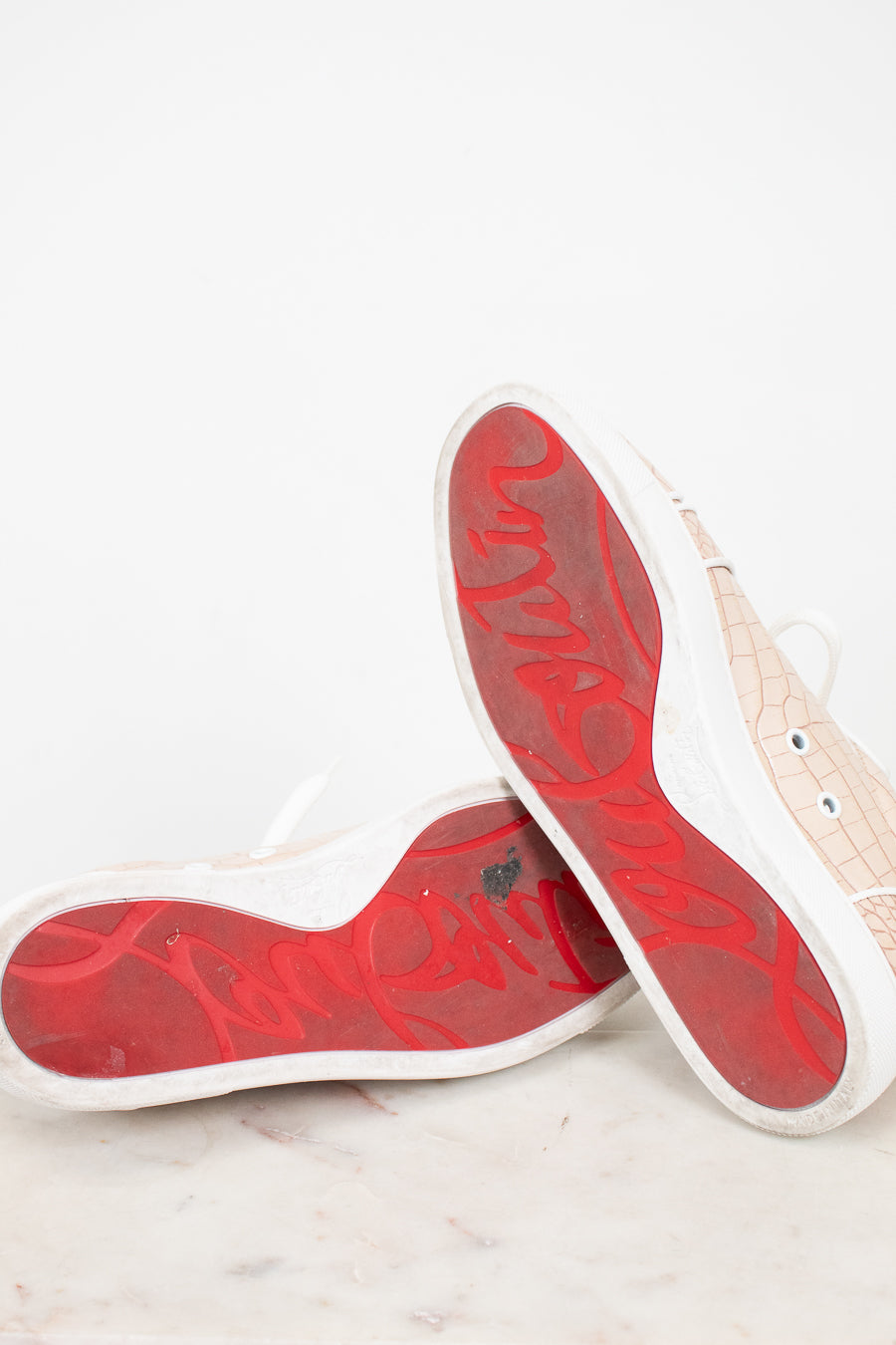 Red soles of sneakers on a light gray surface