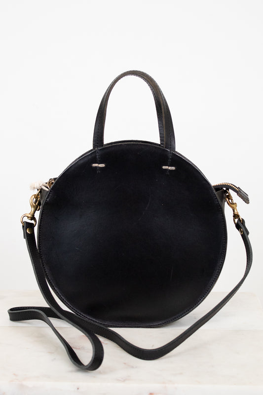 Black handbag with gold accents on a white background